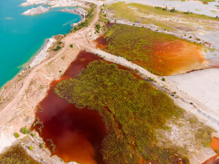 Colored lakes among rock dumps of abandoned quarry, aerial view