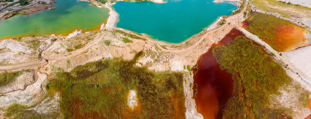 Colored lakes among rock dumps of abandoned quarry, aerial view