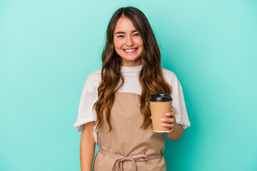 Young caucasian store clerk woman holding a takeaway coffee isolated on blue background happy, smiling and cheerful.