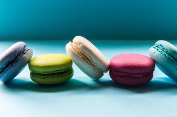 Colorful macaron cookies on a blue background, delicious