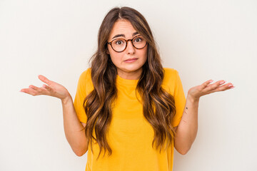 Young caucasian woman isolated on white background doubting and shrugging shoulders in questioning gesture. - obrazy, fototapety, plakaty