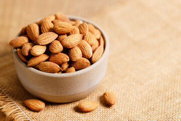 Almonds in a  bowl on wooden table