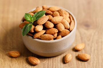 Almonds in a  bowl on wooden table