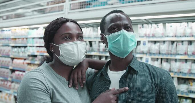 Closeup of woman lean on boyfriend discuss goods in supermarket.African couple in facial mask buy basic necessities in grocery store quarantine and self-isolation, epidemic covid-19,close relation 4k