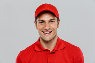 Young delivery man wearing uniform smiling and looking at camera