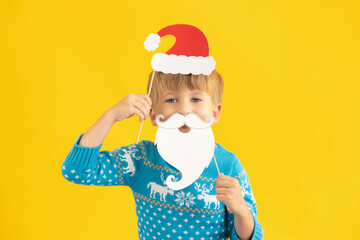 Happy child holding Santa Claus hat and beard