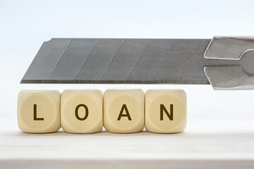 Cut existing loan cost / rate cuts on existing loan, financial concept : Cutter knife over wood...