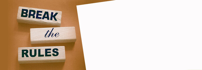 Break the rules phrase on wooden blocks on dark grey. Behavior concept or innovative business...