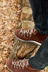 Top viewoman standing with hiking mountain boots on autumn leaves and wood background, relaxing,  local travel, mental health. Copy space