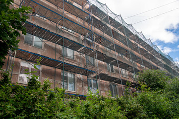 Fototapeta na wymiar facade of an apartment building in scaffolding. Renovation of the facade