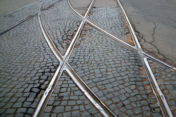 abstract background with tram rails on paving stones and asphalt