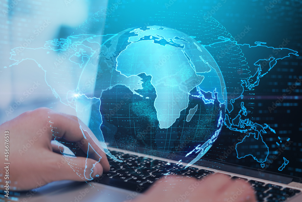 Aufkleber Close up of hands at desktop using laptop keyboard with creative glowing globe interface on dark background. Technology, network and online data concept. Double exposure.