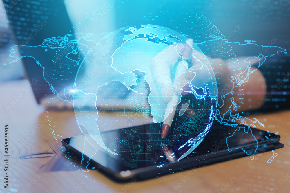 Aufkleber Close up of hands at desktop using pad with creative glowing globe interface on dark background. Technology, network and online data concept. Double exposure.