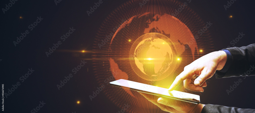 Poster hand holding tablet with glowing globe hologram on dark background with mockup place. digital interf
