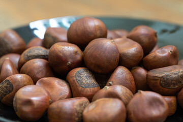 Macro photo of roasted chestnuts in a black dish