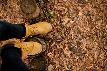 Top view woman standing with hiking mountain boots on autumn leaves and wood background