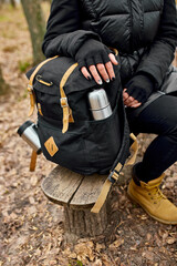 Unrecognizable woman backpacker traveler sitting on bench, travel accessory, relaxing