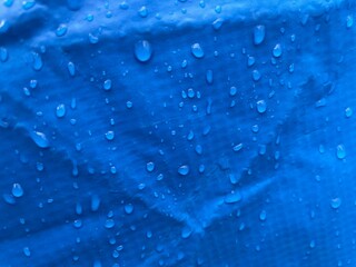 Close up water drops on sky blue tone background. Abstarct ultramarine wet texture with bubbles on window glass surface. Raindrop, Realistic pure water droplets condensed for creative banner design