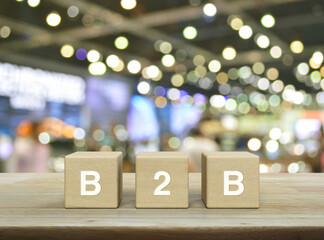 B2B letter on block cubes on wooden table over blur light and shadow of shopping mall, Digital online marketing, Business to business marketing and strategy concept