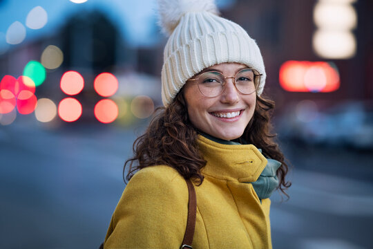Smiling woman on street during winter dusk
