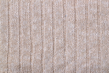 Beige texture of knitted wool sweater. Hand knitting.