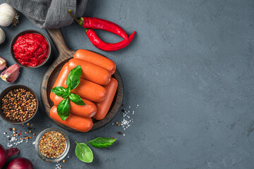 Sausages, basil, pepper and spices on a gray-blue background.