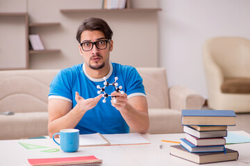 Young male student physicist studying molecular model