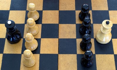 Pieces on a chessboard. The pawns are in a row, behind the pawns is the opponent's queen