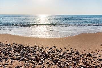 Sea pebbles on the coast at sunrise with out of focus sea background