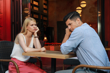 Bored couple having unsuccessful date in cafe