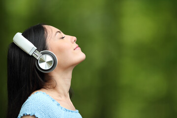 Asian woman meditating listening guide on headphones