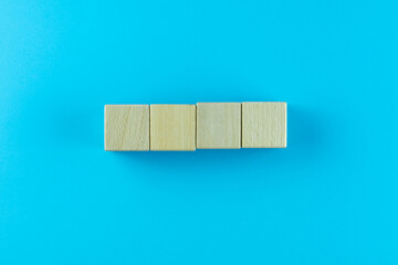 Pyramid of four wooden cubes, on blue background