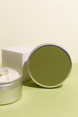 White cream in round aluminum metal tin on neutral background. Natural cosmetic product. Face and body skin care, cosmetic products.