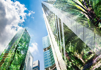 green city - double exposure of lush green forest and modern skyscrapers windows
