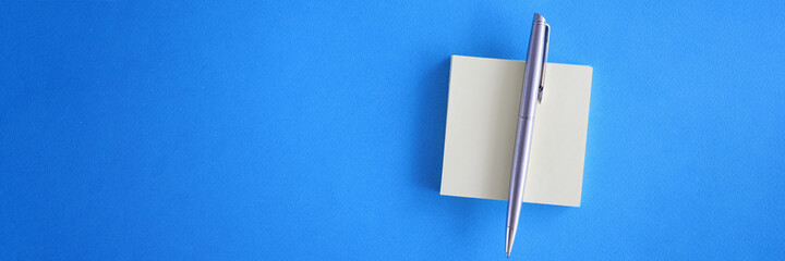 White sticky notes with pen on light blue background