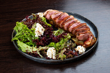Duck breast with lettuce and cream cheese. On a wooden background