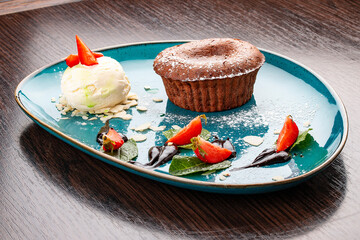 Chocolate fondant with ice cream balls. On a wooden background
