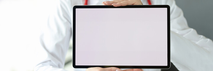 Female doctor is holding tablet with white screen
