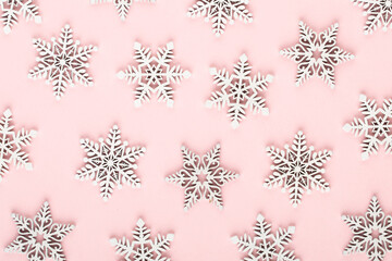 Christmas background. White snow decorations on a pink background.