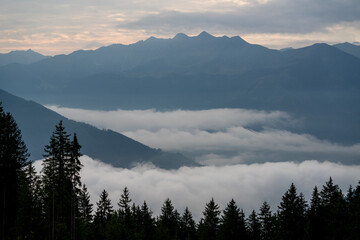 wonderful view in the morning with fog in the valley and a cloudy sky on the mountains