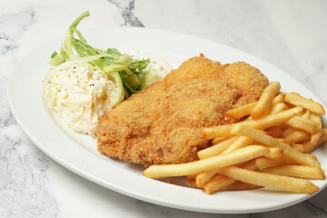 crispy chicken cutlet with fries and salad