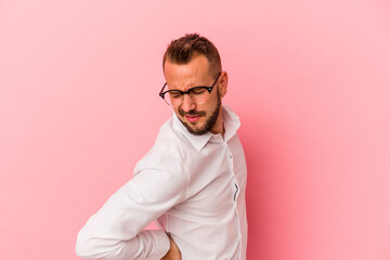 Young caucasian man with tattoos isolated on pink background  suffering a back pain.