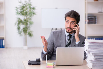 Young male employee and too much work in the office