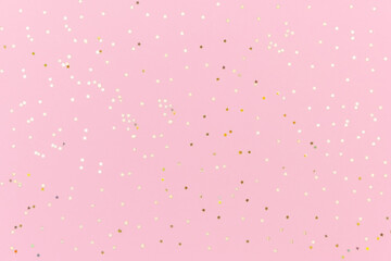 Pink background with gold sequins. Festive backdrop for your projects. Background for your product presentation. Top view, copy space.