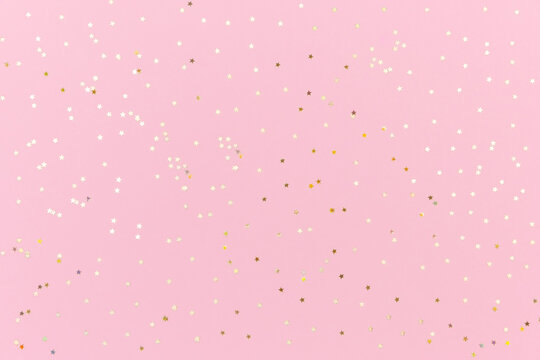 Pink background with gold sequins. Festive backdrop for your projects. Background for your product presentation. Top view, copy space.