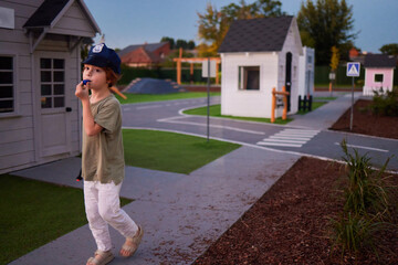 cute little boy playing the policeman, keeps order in the city , blowing a whistle