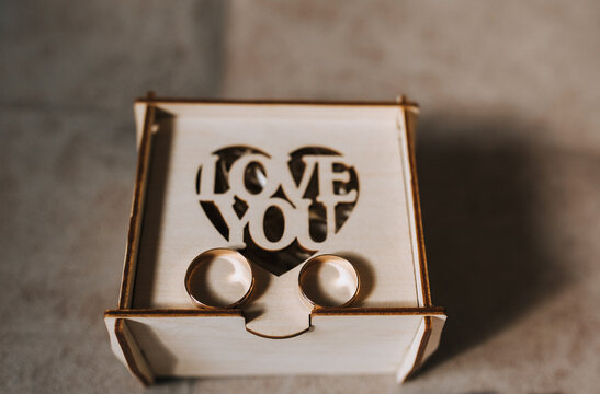 Wedding accessories for the bride close-up: wooden box, gold rings. Photography, concept, morning preparation.