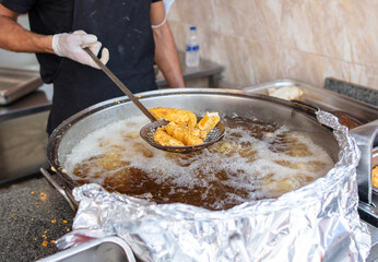 The cook fries fish in batter