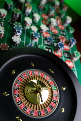 
Casino. Gambling games theme.  Roulette wheel, dice and poker chips on the casino felt green table.
