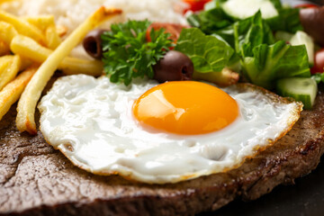 Portugal dish Bitoque made from beef steak with a fried egg, rice, french fries and vegetables